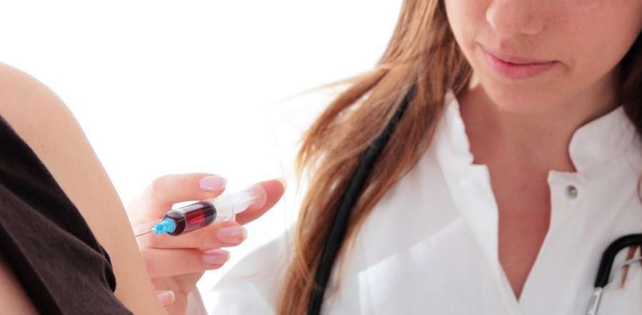 Travel Medicine doctor with syringe doing a Vaccination